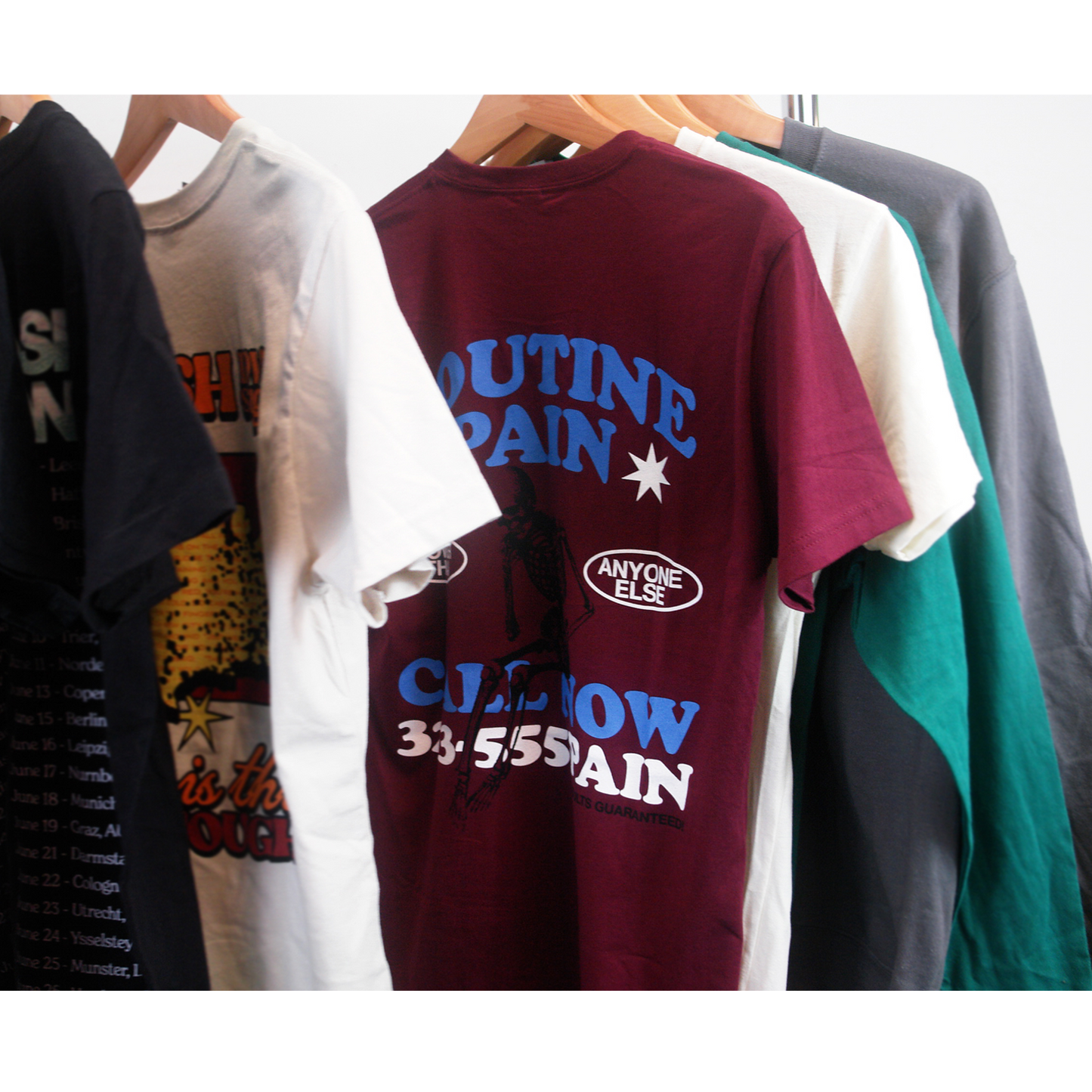 image of the front of a maroon tee shirt on a white background. front of tee has a small chest print on the right. stacked in blue says spanish love songs and below in white says results guaranteed!